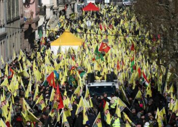 Kurds wave Kurdistan Workers' Party flags (PKK) and flag depicting Kurdistan Worker's Party (PKK) leader Abdullah Ocalan during a demonstration of several thousand people from all around Europe to mark the 26th anniversary of the arrest of PKK founder and to demand his liberation in Strasbourg, Eastern France, on February 15, 2025. Kurdish militant leader Abdullah Ocalan, founder of the Kurdistan Workers' Party (PKK) serving life without parole on a prison island near Istanbul since 1999, Ocalan could use the February 15 anniversary of his arrest to address Ankara's call for the PKK to lay down its arms, possibly securing himself early release. (Photo by Frederick FLORIN / AFP)