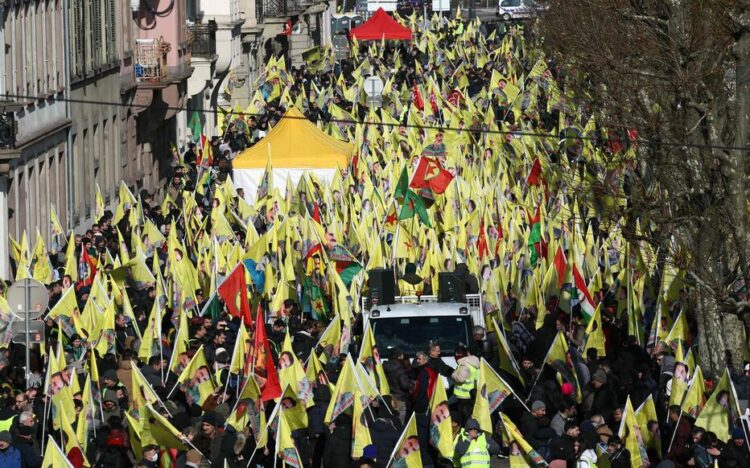 Kurds wave Kurdistan Workers' Party flags (PKK) and flag depicting Kurdistan Worker's Party (PKK) leader Abdullah Ocalan during a demonstration of several thousand people from all around Europe to mark the 26th anniversary of the arrest of PKK founder and to demand his liberation in Strasbourg, Eastern France, on February 15, 2025. Kurdish militant leader Abdullah Ocalan, founder of the Kurdistan Workers' Party (PKK) serving life without parole on a prison island near Istanbul since 1999, Ocalan could use the February 15 anniversary of his arrest to address Ankara's call for the PKK to lay down its arms, possibly securing himself early release. (Photo by Frederick FLORIN / AFP)